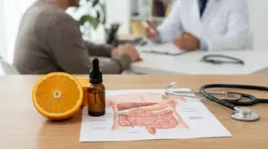 Arancia, contagocce e schema dell’apparato digerente su un tavolo durante un consulto medico sul pancreas