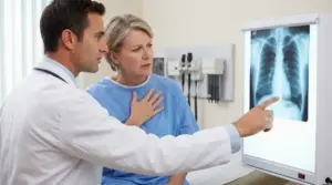 Medico mostra una radiografia del torace a una paziente preoccupata durante una visita ai polmoni